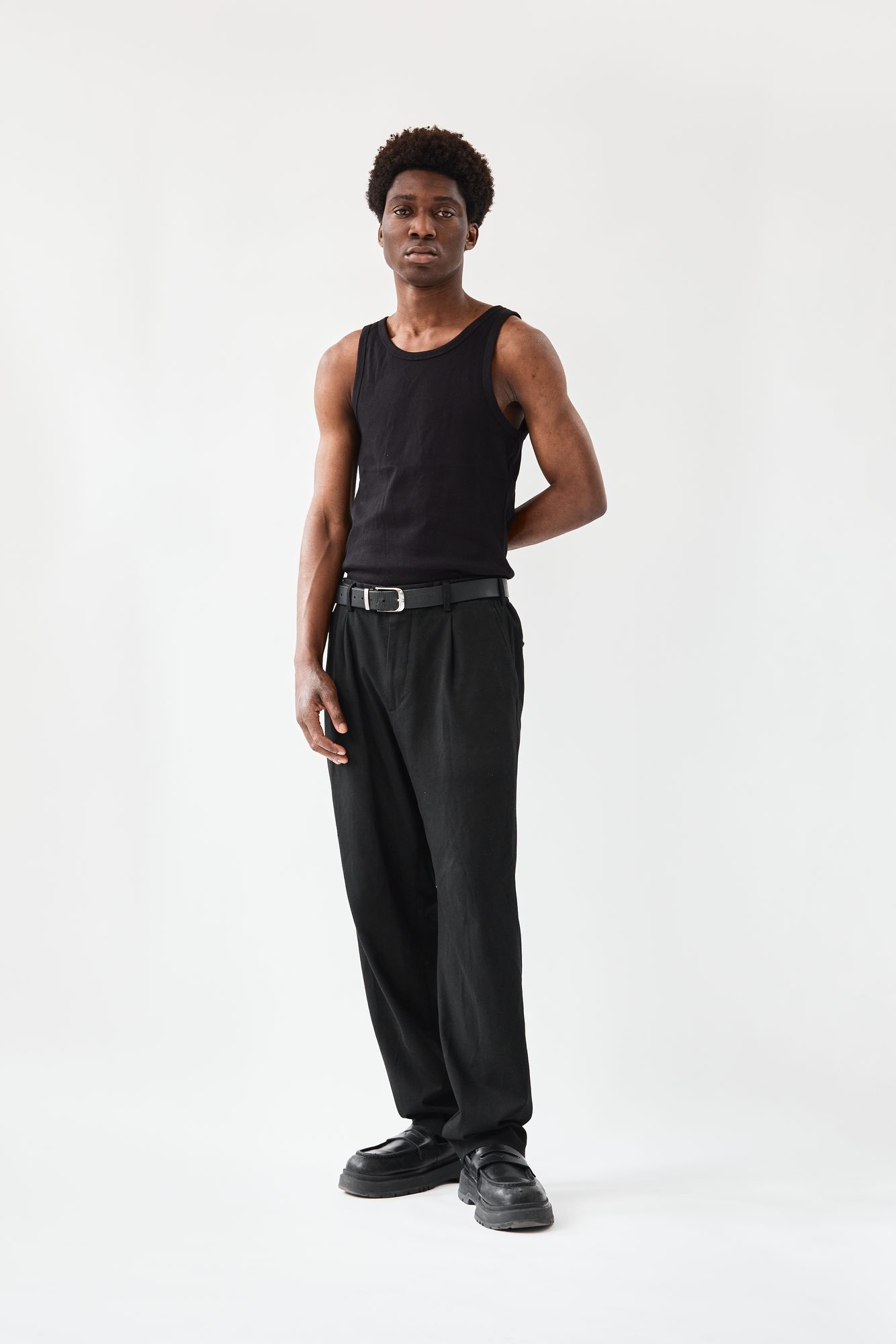 COLORBLND Male Model in schwarzem Tank-Top und weiter Hose – Clean Editorial
